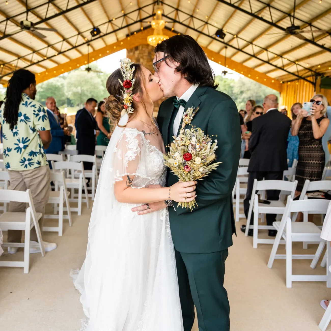 a man and woman kissing under a tent down the aisle at their wedding at Sowell Farms Milton FL | KDH Weddings