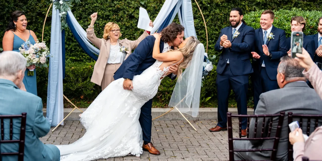 a man and woman kissing in front of a group of people Pensacola Wedding Photography - Dakhota & Jesse at 5eleven Palafox