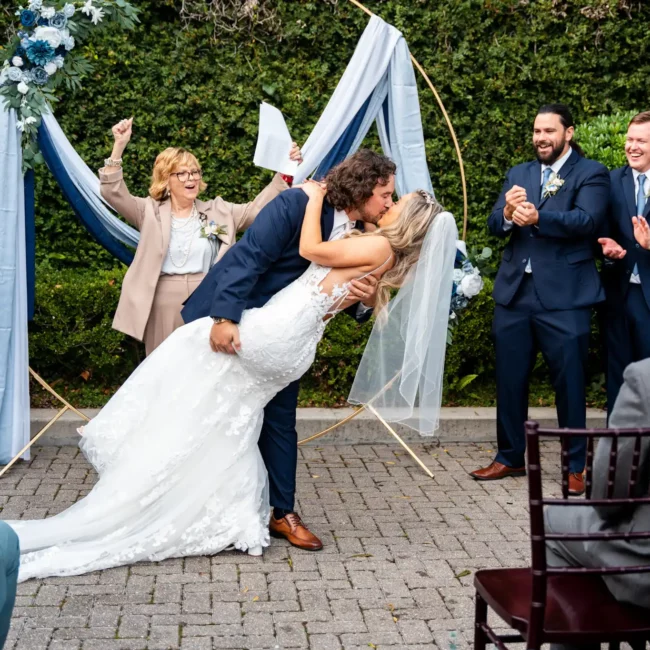 a man and woman kissing in front of a group of people Pensacola Wedding Photography - Dakhota & Jesse at 5eleven Palafox