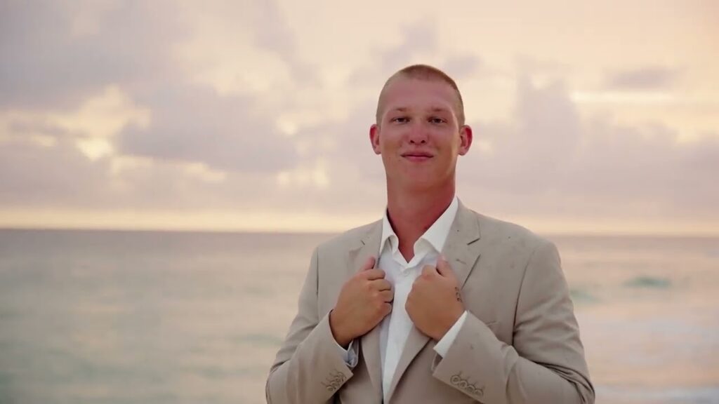 How Much Does a Wedding Videographer Cost on the Gulf Coast? (2027 Guide) 3 Groom in a tan linen suit on the beach at sunset, from the wedding film of Chance and Sam's Destin, Florida wedding