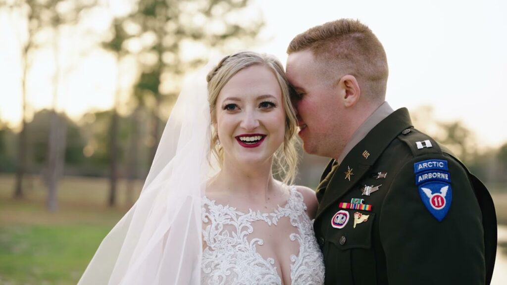How Much Does a Wedding Videographer Cost on the Gulf Coast? (2027 Guide) 2 Hunter in his Army dress uniform whispering to Kathryn in her lace gown and veil, a still from their wedding film