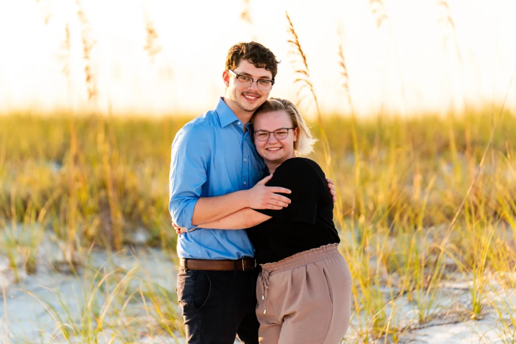 Caleb proposing to Jordan on the Navarre Beach pier at sunrise, photographed by KDH Weddings