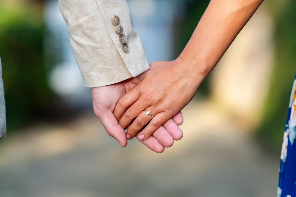 19 Unique Engagement Photo Locations in Mobile, AL (2025 Update) 10 a close up of a couple holding hands with a woman wearing a new engagement ring - Engagement Shoot in Mobile, AL at springhill college by KDH Weddings