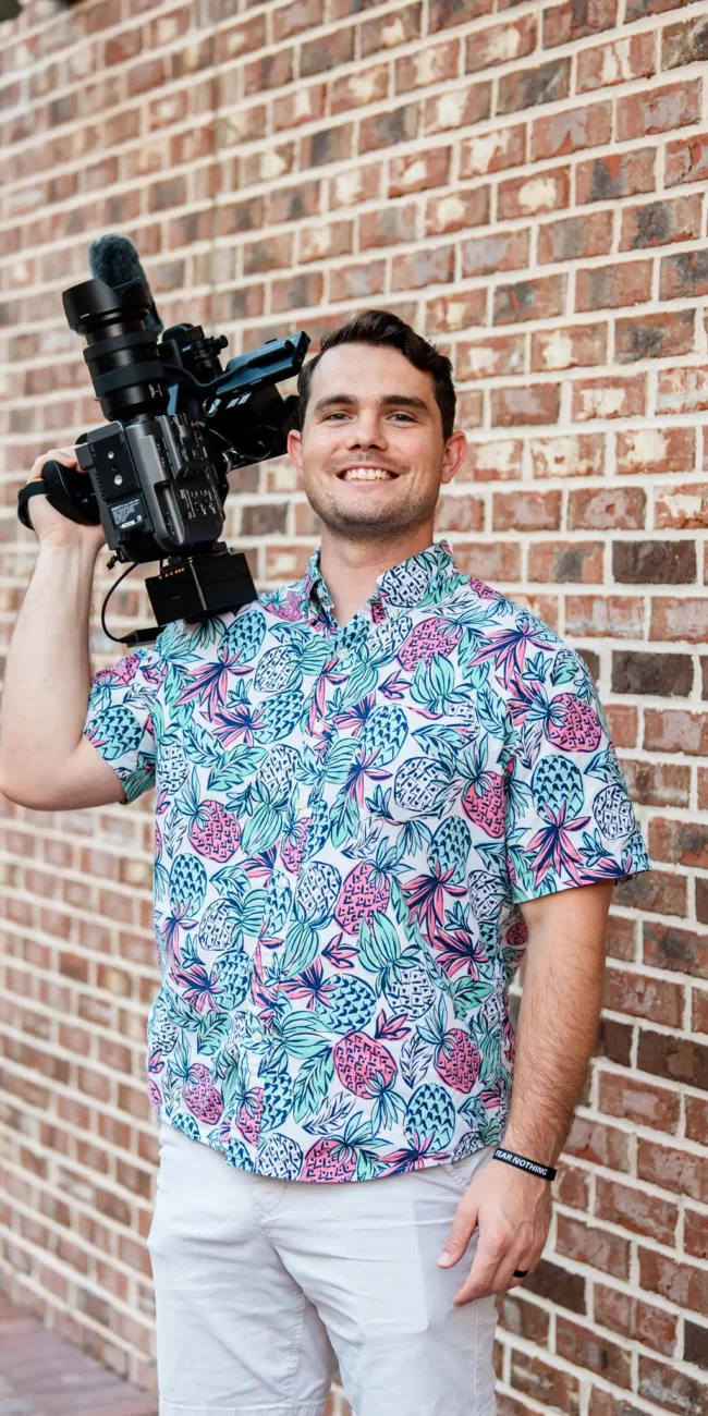 Korbin Henderson Owner of KDH Weddings holding video camera in pineapple fun shirt