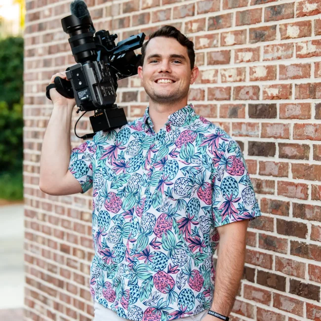 Korbin Henderson Owner of KDH Weddings holding video camera in pineapple fun shirt