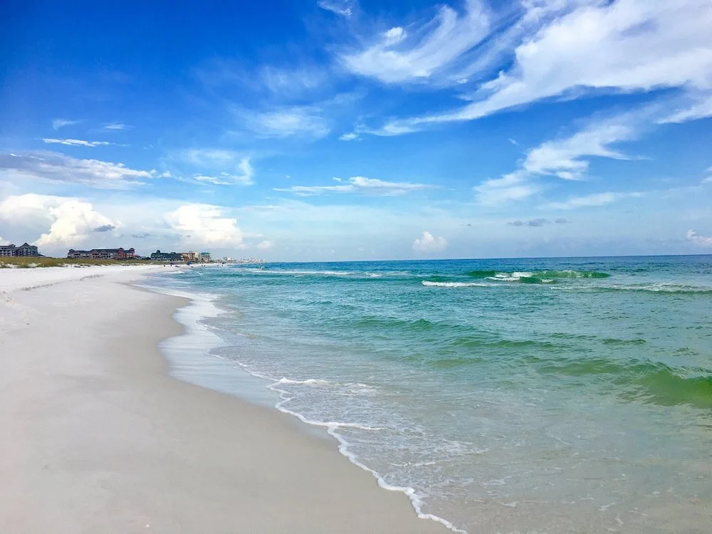 Where to Elope on the Gulf Coast: Pensacola Beach to 30A 4 Empty white sand and turquoise surf at Henderson Beach State Park in Destin, with the low dune line and beachfront condos far in the distance