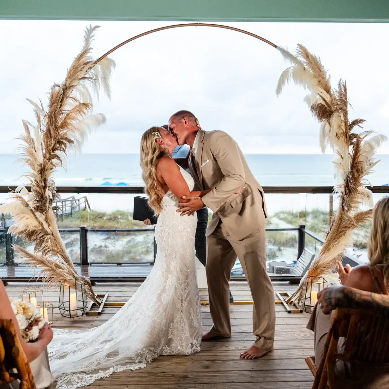 a man and woman kissing under an arch first kiss after getting married in destin fl | KDH Weddings