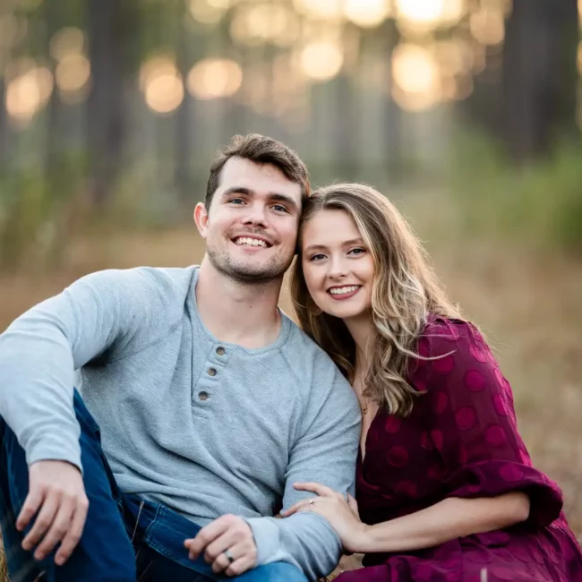 Korbin Henderson of KDH Weddings with his wife smiling wedding rings on hands in a forest