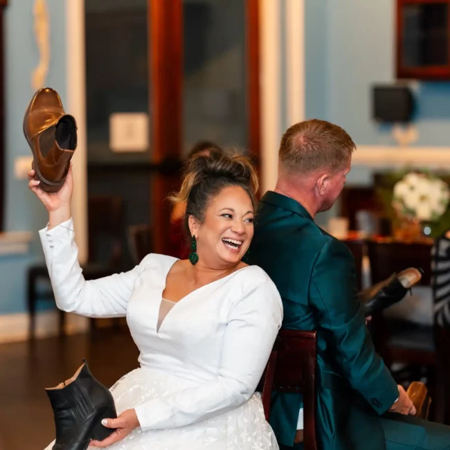 husband and wife playing a game on dance floor with shoes in each hand