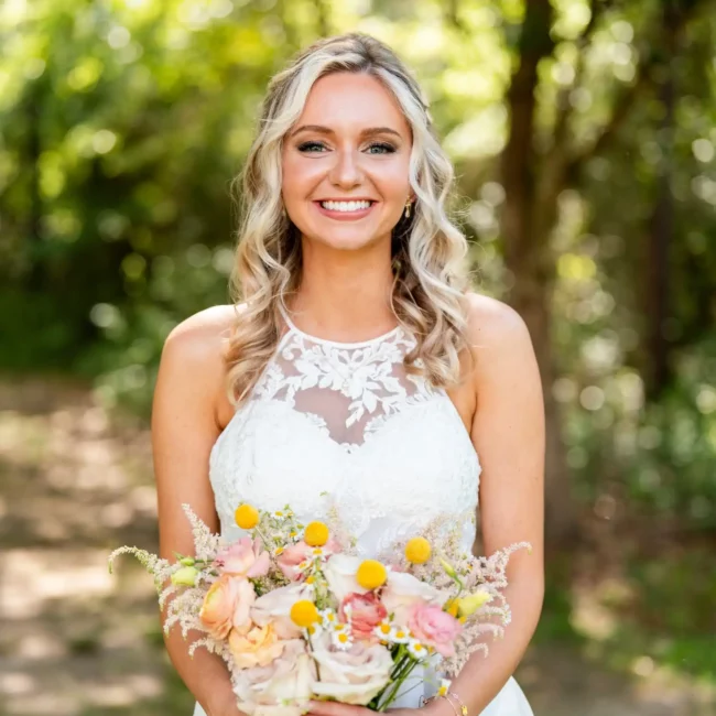 bride holding flowers smiling directly at camera