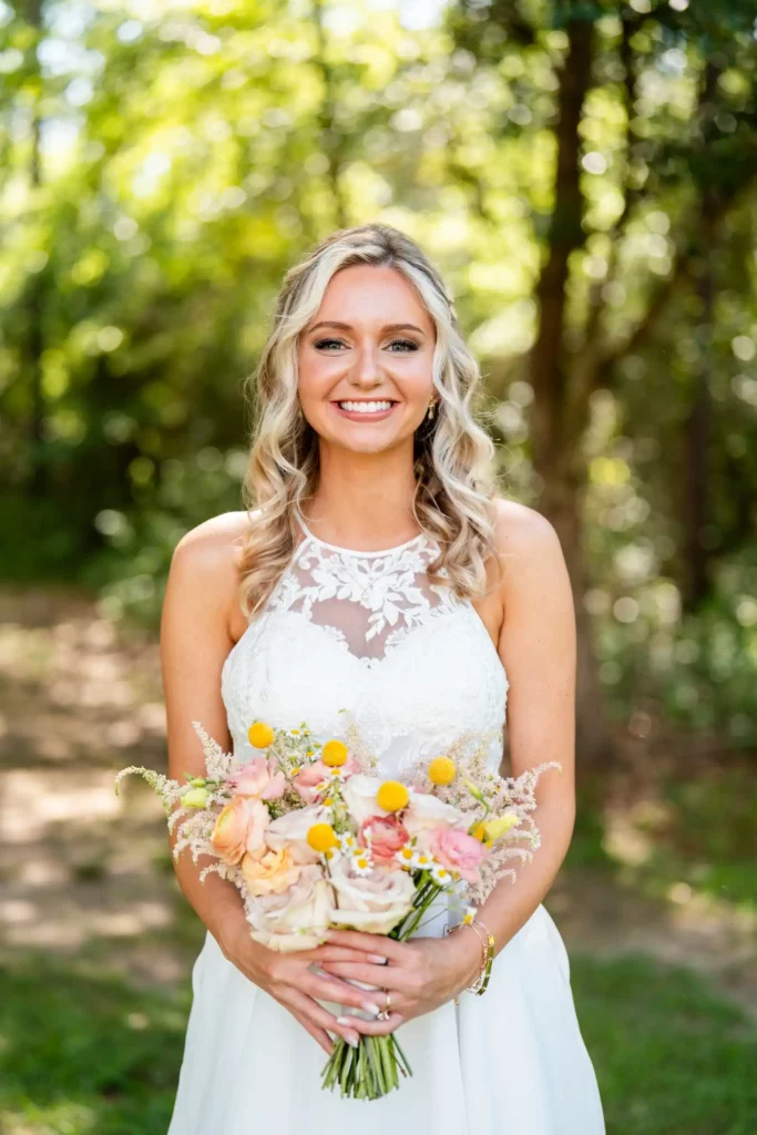 bride holding flowers smiling directly at camera
