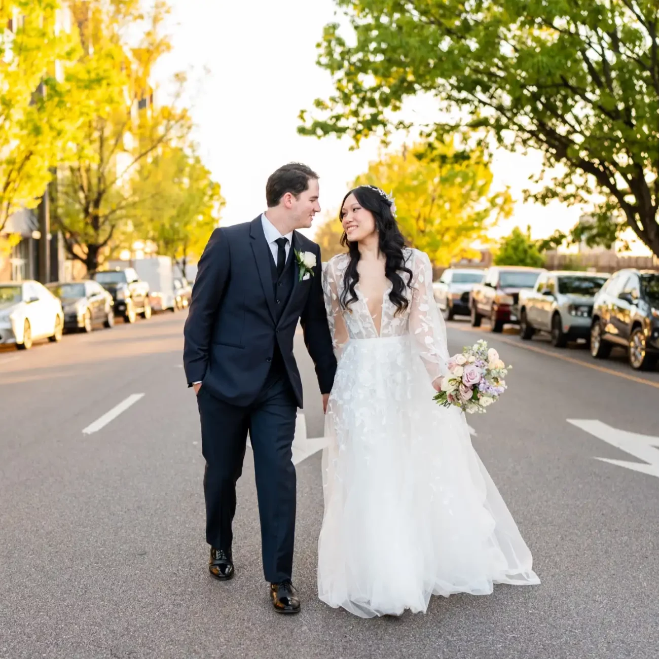 husband and wife smiling walking down the middle of a street - KDH Weddings