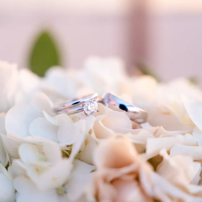 wedding rings on top of white flowers