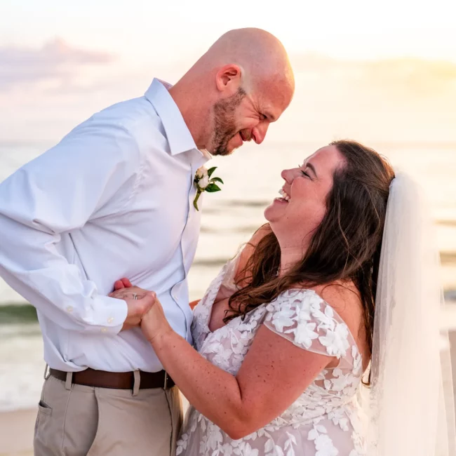 Chad & Rena holding hands and smiling looking into each others eyes after getting married on Orange Beach