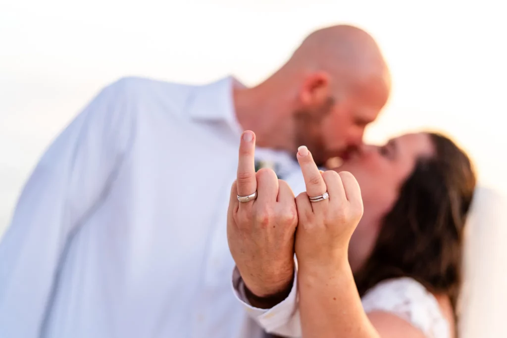 Panama City Beach Wedding Photographer 7 Chad & Rena putting up the ring finger as if it were the middle finger as a funny "we just got married - F-You!"