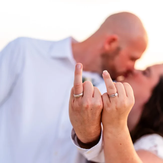 Chad & Rena putting up the ring finger as if it were the middle finger as a funny "we just got married - F-You!"