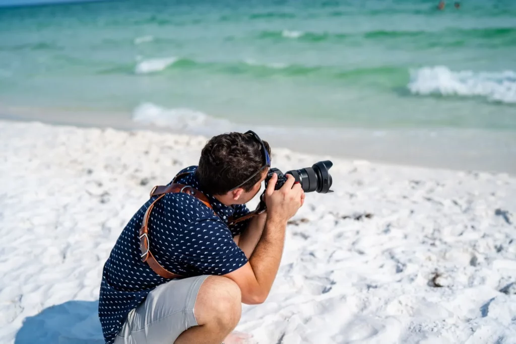 Korbin Henderson - owner: kdh weddings BTS of himself at a wedding taking photographs on pensacola beach