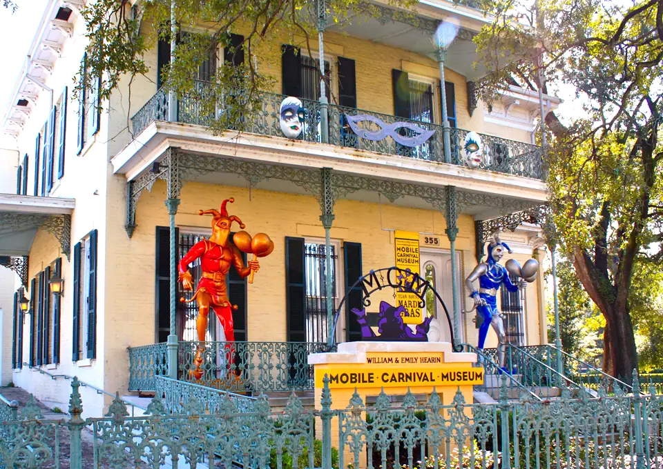 19 Best Engagement Photo Spots in Mobile, Alabama (With Parking, Timing & Real Session Examples) 15 Mobile, AL Carnival Museum Balcony Colorful yellow New Orleans home displays Mardi Gras masks, jesters, and floats for the Mobile Carnival Museum behind ornate ironwork.