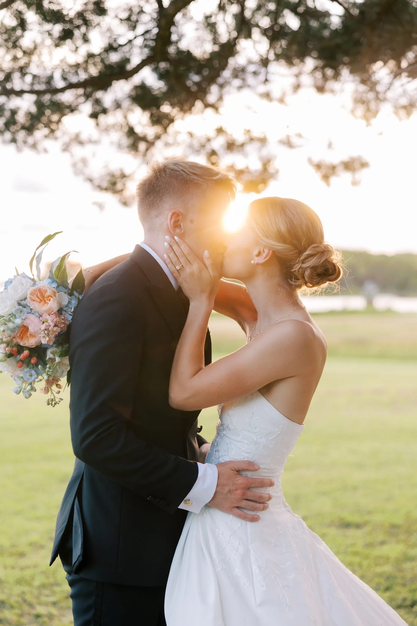 Pensacola Wedding Photographer - KDH Weddings 6 Jake and Lauren kiss with the evening sun flaring between them beside Santa Rosa Sound