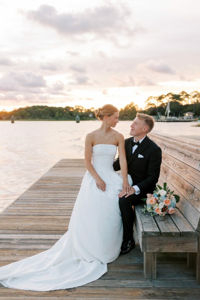Jake & Lauren's Hurlburt Field Wedding on Santa Rosa Sound 9 Jake and Lauren on a wooden bench on the dock over Santa Rosa Sound