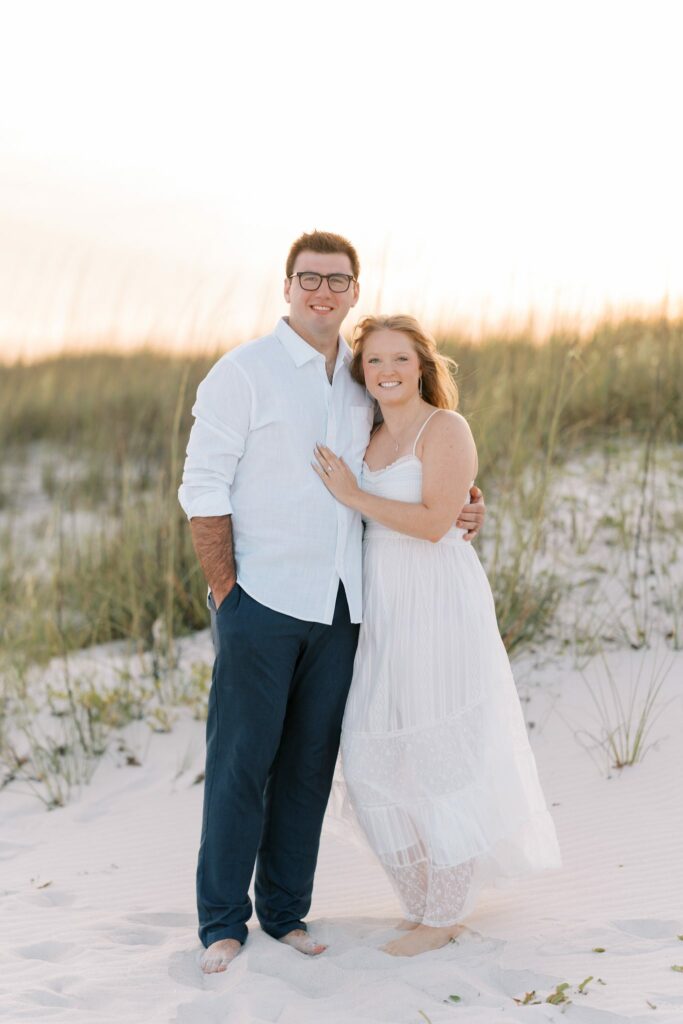 Andrew & Katie's Pensacola Beach Engagement Photos and Film 3 Andrew and Katie stand together in front of the dunes on Pensacola Beach