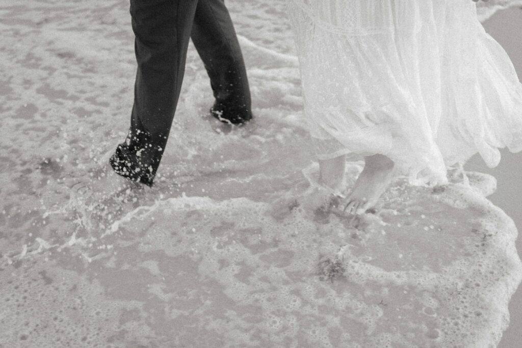 Andrew & Katie's Pensacola Beach Engagement Photos and Film 7 Black and white close-up of the couple's feet in the surf