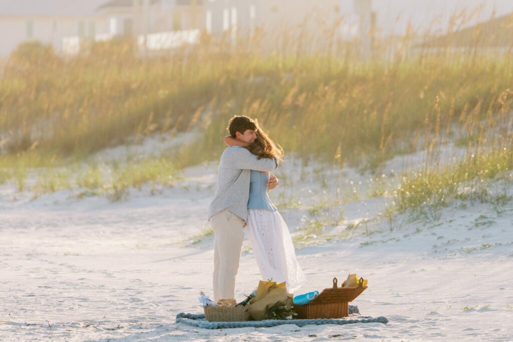 Hayes & Mallory's Surprise Proposal on Pensacola Beach 1 Hayes and Mallory embrace right after his surprise proposal beside a picnic setup on Pensacola Beach
