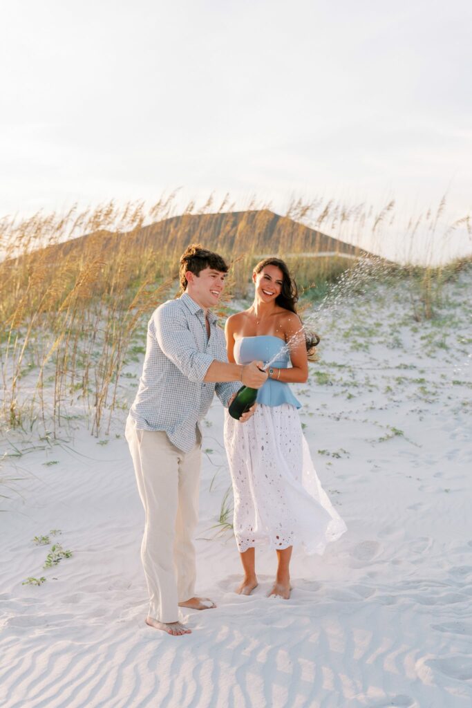 Hayes & Mallory's Surprise Proposal on Pensacola Beach 5 Hayes pops champagne after the proposal on Pensacola Beach