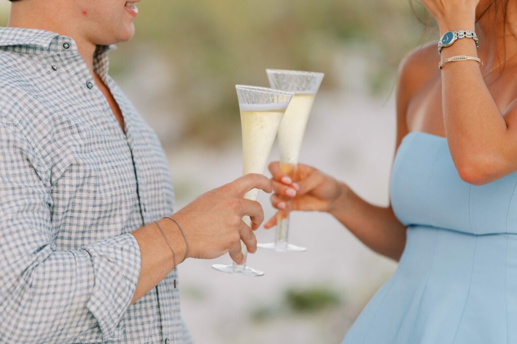 Hayes & Mallory's Surprise Proposal on Pensacola Beach 6 Close-up of a champagne toast after the surprise proposal