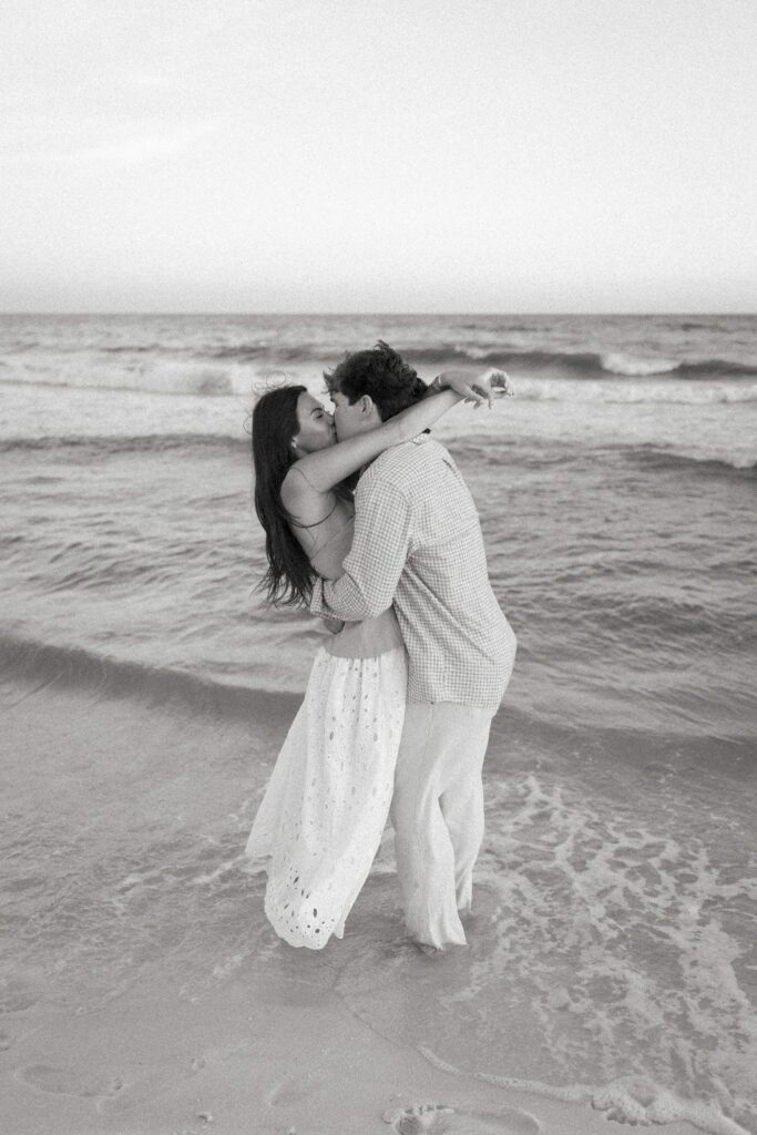 Hayes & Mallory's Surprise Proposal on Pensacola Beach 12 Black and white photo of the couple kissing in the surf