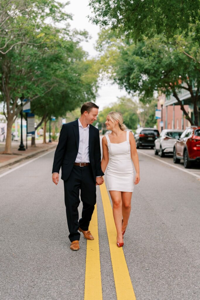 Sean and Brooklin walk down the center line of a tree-lined downtown Pensacola street