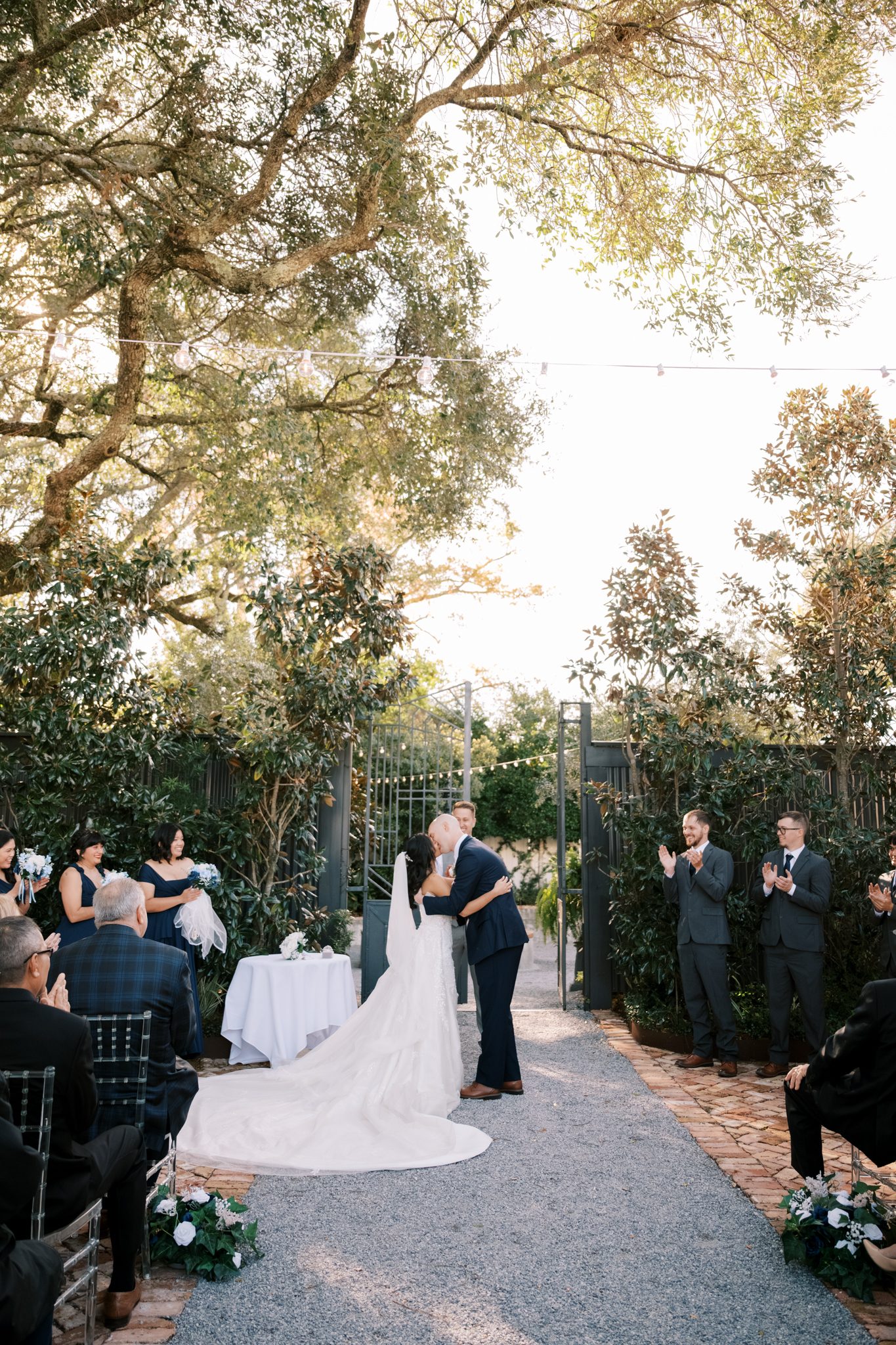Bret and Ella at the end of the ceremony aisle under the oaks at Supposey Warehouse and Gardens