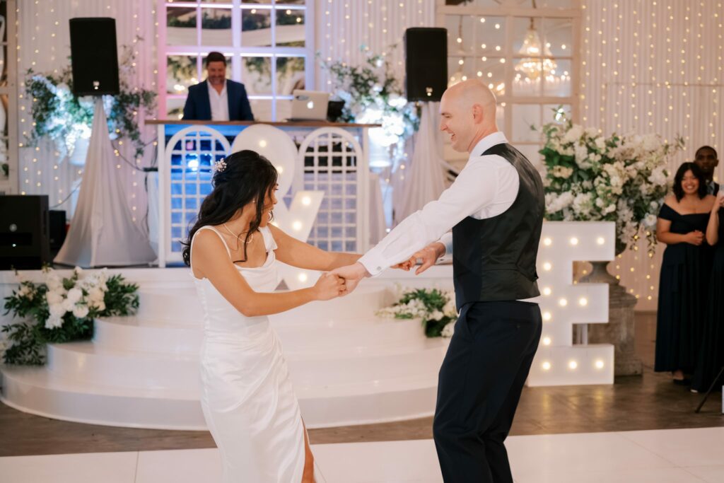 Bret & Ella's Spring Warehouse Wedding in Pensacola 8 Bret and Ella dance in front of lit marquee letters at their Supposey reception