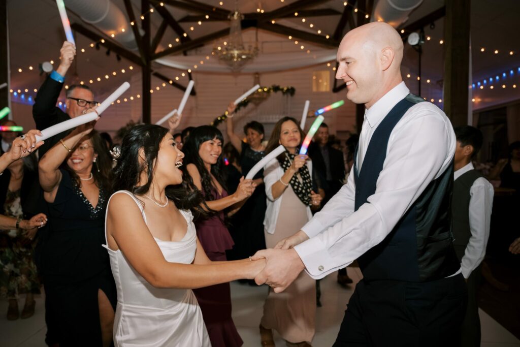 Bret & Ella's Spring Warehouse Wedding in Pensacola 9 Guests waving glow sticks on the dance floor at Supposey