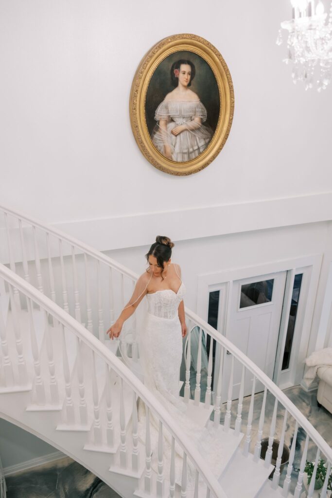 Nick & Amanda's Supposey Warehouse Wedding in Pensacola 2 Bride in her gown on the white spiral staircase inside the Supposey Warehouse bridal suite