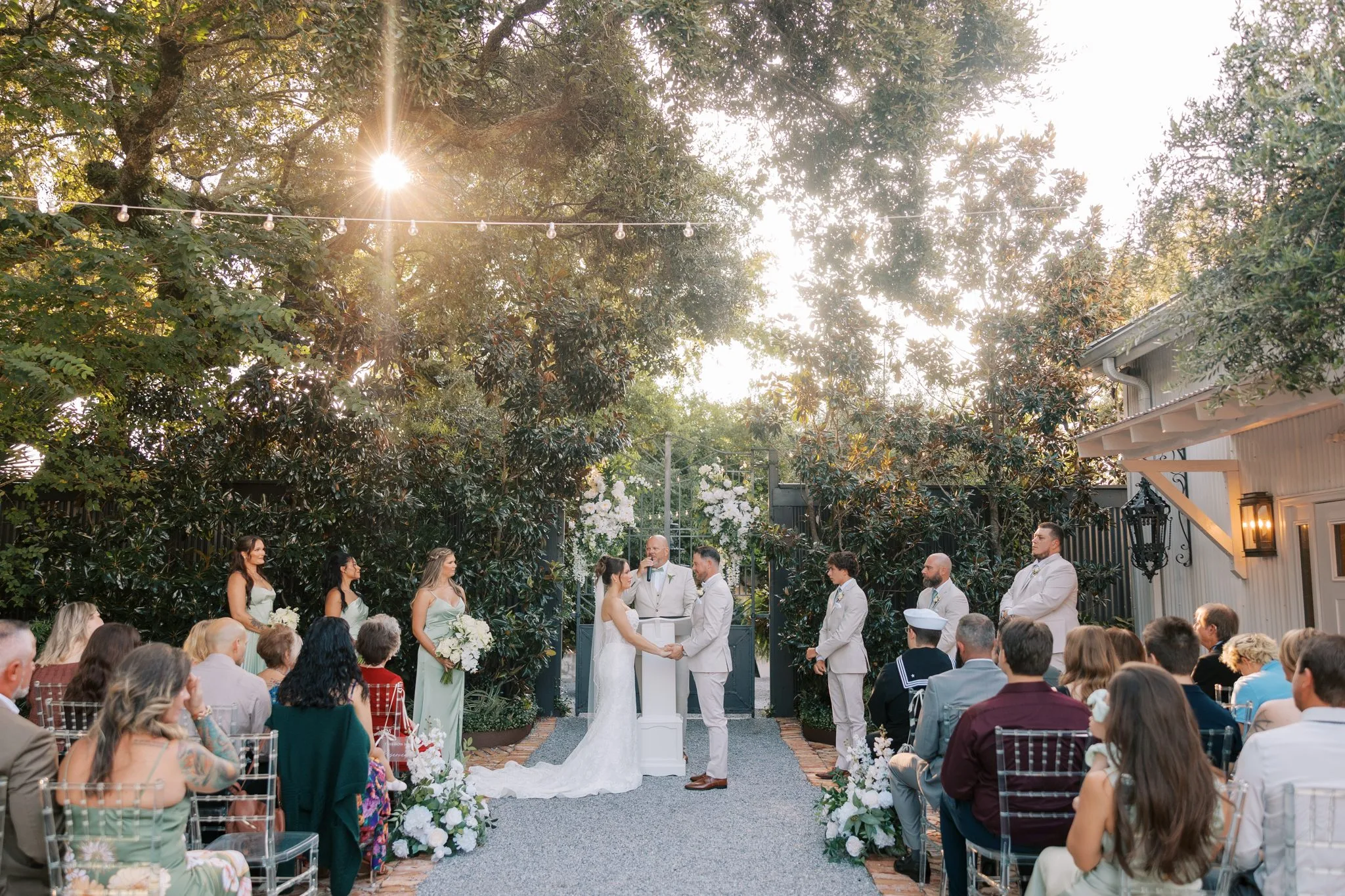 Pensacola Wedding Photographer - KDH Weddings 11 Guests seated along the gravel aisle under the oaks during the garden ceremony at Supposey Warehouse and Gardens