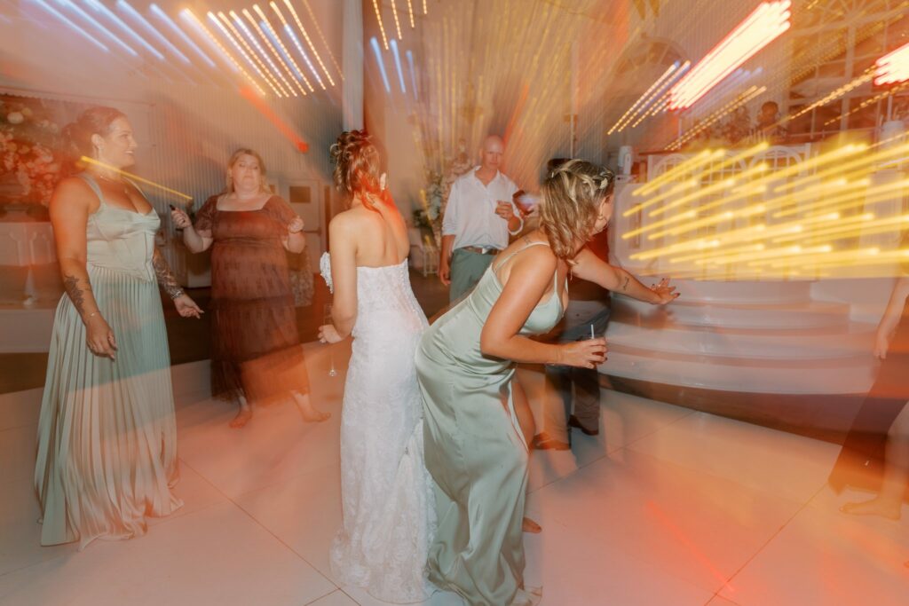 Nick & Amanda's Supposey Warehouse Wedding in Pensacola 15 Motion-blur photo of the bride and bridesmaids dancing at the Supposey reception