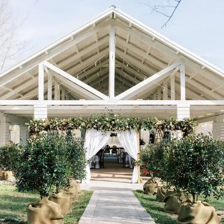 Josh & Haley's Hidden Oak Farm Wedding in Milton, FL 3 Entrance to the covered Orchard House at Hidden Oak Farm with potted trees along the walk