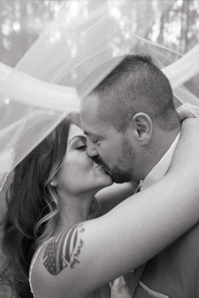 Josh & Haley's Hidden Oak Farm Wedding in Milton, FL 19 Black and white photo of Josh and Haley kissing under her veil at Hidden Oak Farm in Milton, FL
