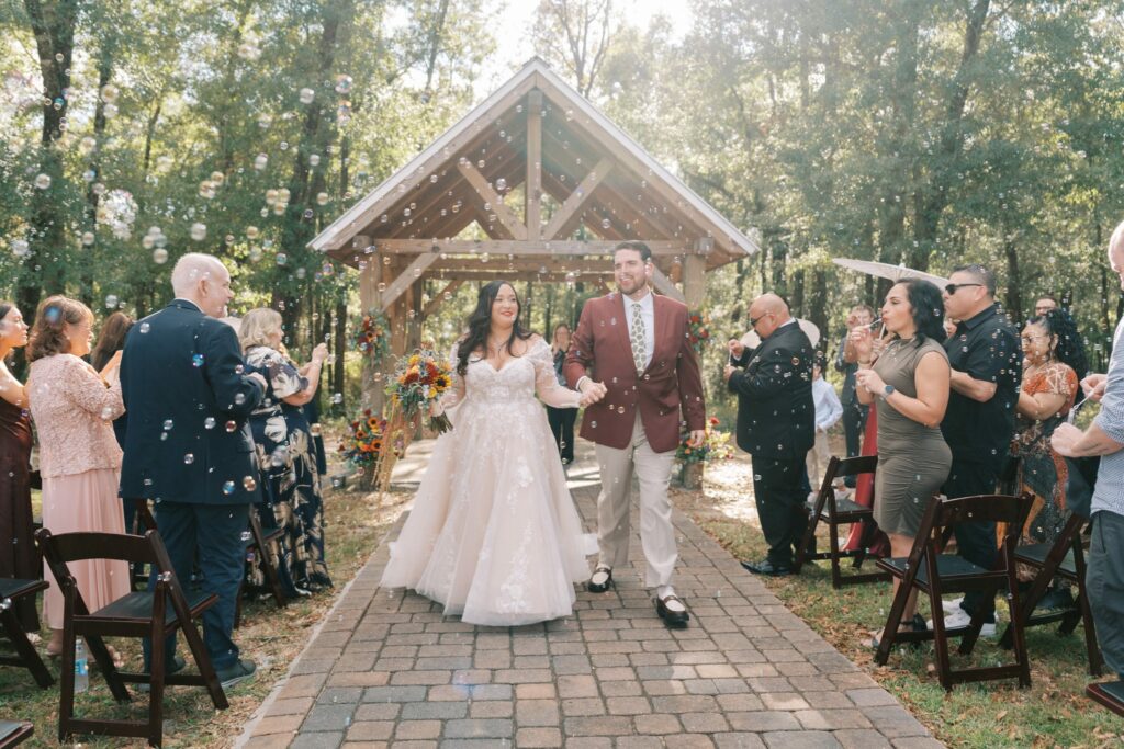 Jacob & Angelina's Holland Farms Wedding 8 Jacob and Angelina walking back down the brick aisle after their Holland Farms ceremony as guests cheer