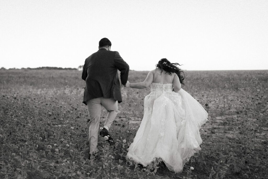 Jacob & Angelina's Holland Farms Wedding 12 Black and white photo of Jacob and Angelina walking away across the open field at Holland Farms, Milton FL