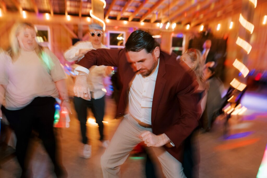 Jacob & Angelina's Holland Farms Wedding 19 Jacob dancing in his burgundy jacket at the barn reception at Holland Farms in Milton, FL