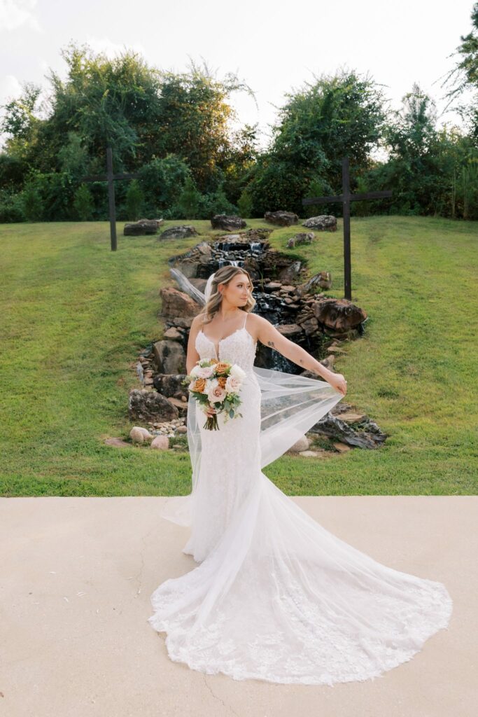Anthony & Renee's Wedding at The Venue at Hidden Falls 8 Renee lifting her long veil in front of the waterfall at Hidden Falls, Anthony and Renee's wedding
