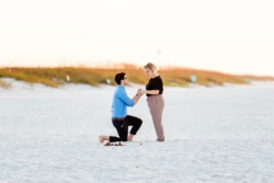 Beautiful & Heartfelt Proposal on Navarre Beach Pier 3 a man and woman standing on a beach holding hands