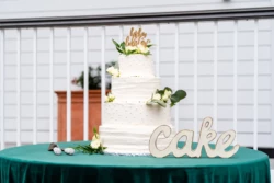 A Perfect USMC Wedding in Pensacola – Bobby & Kaisey’s Big Day 25 wedding cake with the word cake next to it on a green table