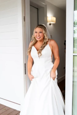 A Perfect USMC Wedding in Pensacola – Bobby & Kaisey’s Big Day 15 bride white dress blonde hair smiling inside a doorframe