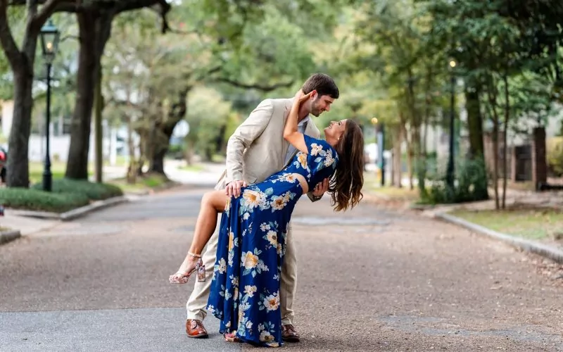 a man holding a woman in a blue dress Charming Engagement photo Shoot in Mobile, AL at springhill college