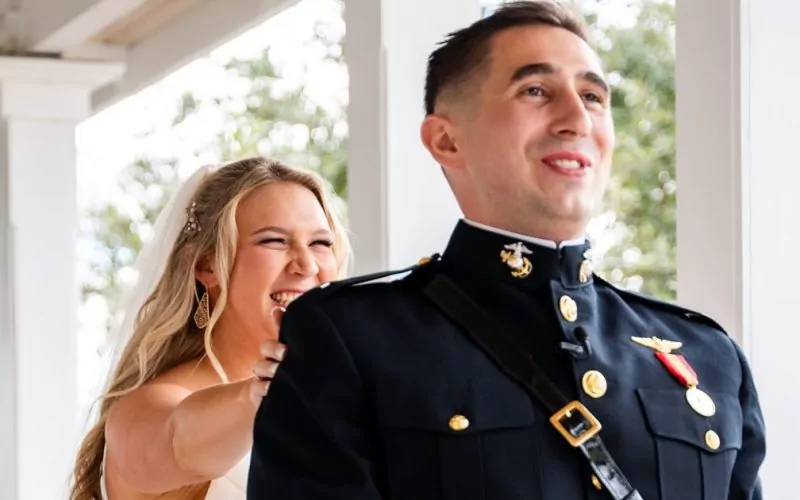 Kaisey laughing beside Bobby in his Marine Corps dress blues on a white columned porch at their Pensacola wedding