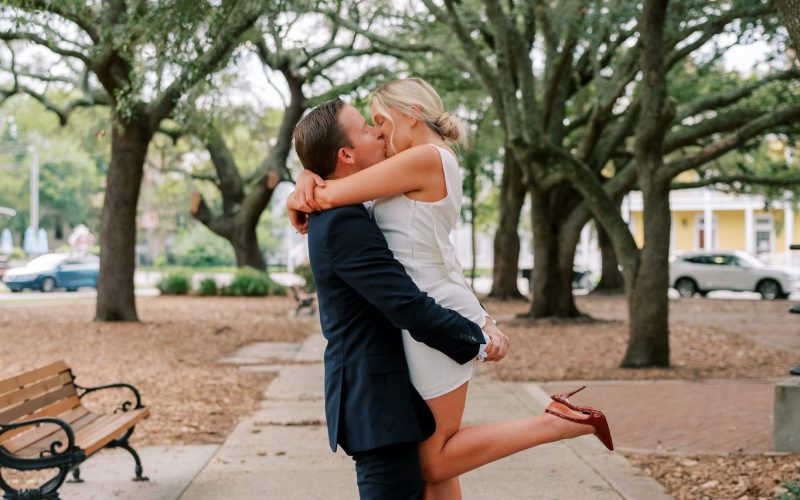 Engaged couple embrace on a brick path beneath the live oaks in Seville Square, Pensacola